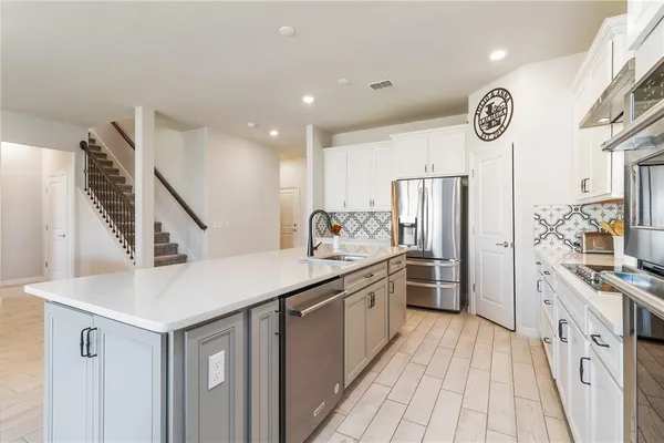 a kitchen with stainless steel appliances a sink stove and refrigerator