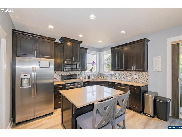 341 Boulder Ridge Drive Sweet Home, OR 97386 - Photo 10 of 32 a kitchen with stainless steel appliances granite countertop a sink a stove and a refrigerator