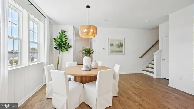 a dining room with furniture a chandelier and wooden floor