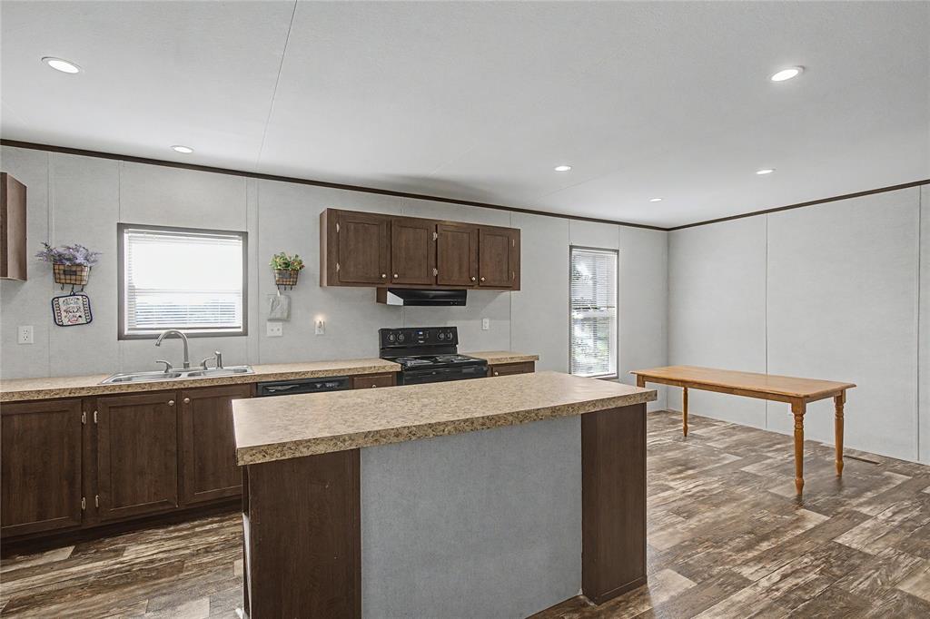 177 New Highland Road Springtown, TX 76082 - Photo 12 of 40 Kitchen featuring wood-finish flooring, recessed lighting, dark wood cabinetry, and light-colored countertops