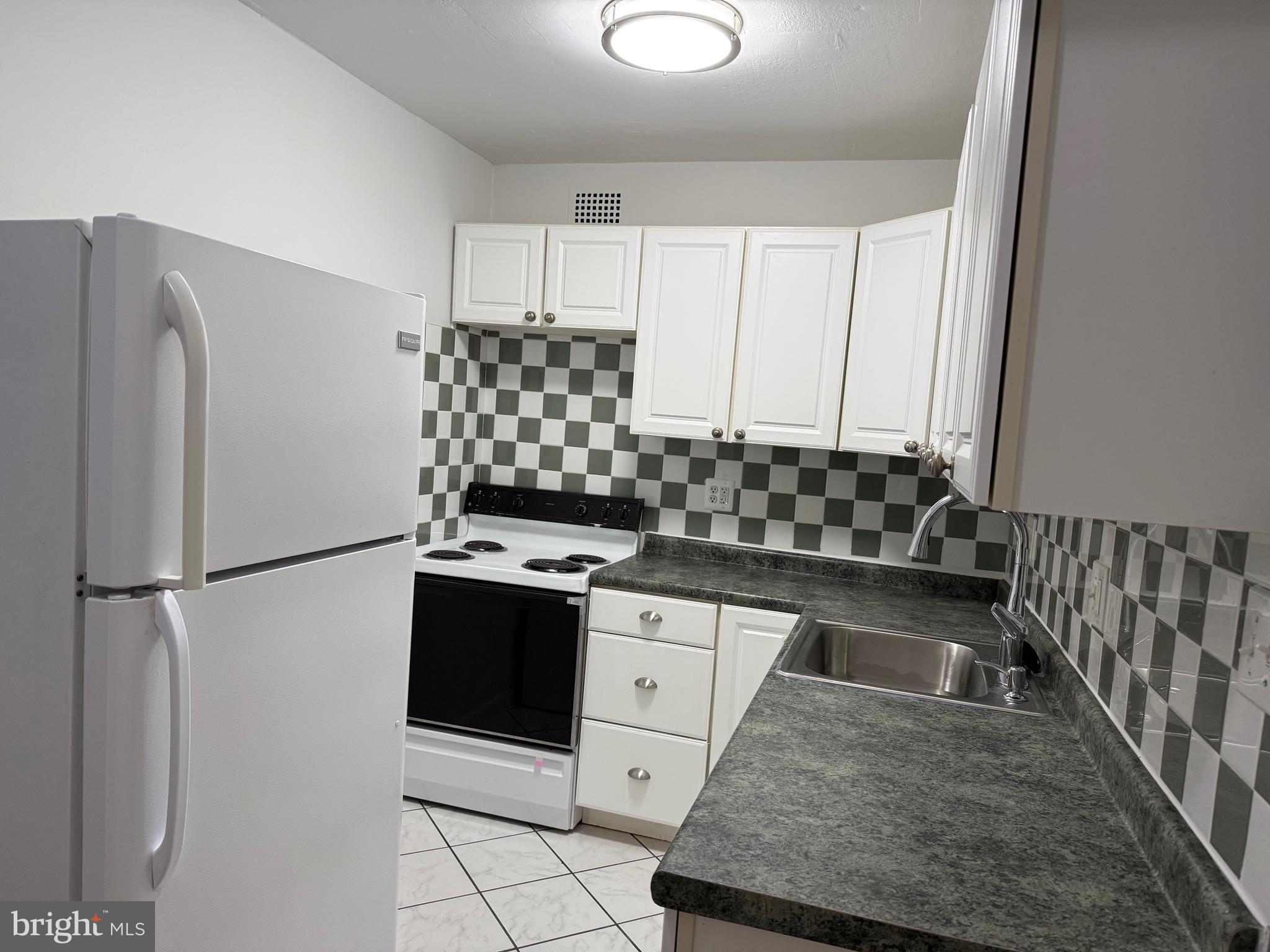 2059 Huntington Avenue, Unit 802 Alexandria, VA 22303 - Photo 1 of 18 a kitchen with stainless steel appliances granite countertop a refrigerator sink stove and white cabinets