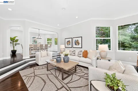 a kitchen with a dining table chairs stove and white cabinets