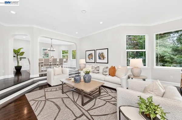 a kitchen with a dining table chairs stove and white cabinets