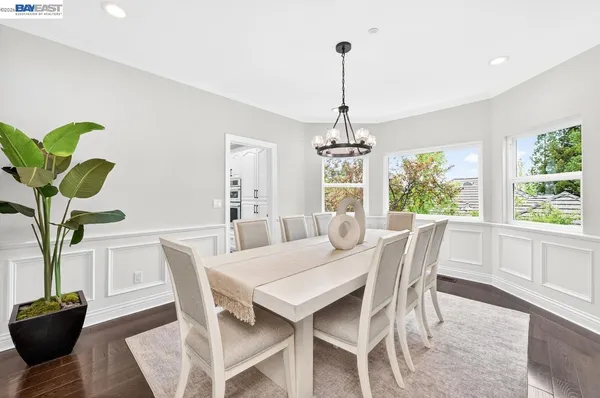 a kitchen with granite countertop white cabinets a window and stainless steel appliances