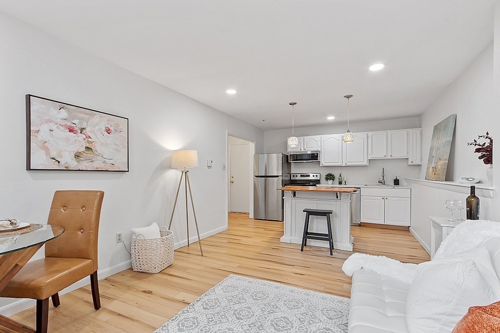 6 Leonard Road, Unit 6 Boxborough, MA 01719 - Photo 4 of 28 a living room with furniture a kitchen island with wooden floor and a view of kitchen