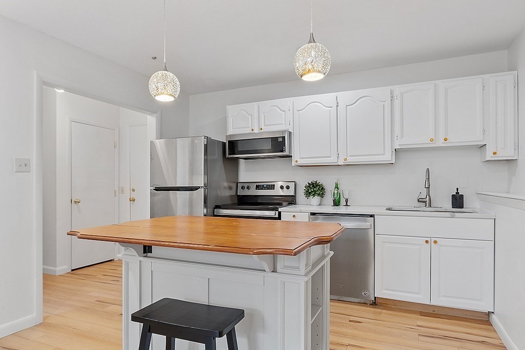 6 Leonard Road, Unit 6 Boxborough, MA 01719 - Photo 5 of 28 a kitchen with stainless steel appliances a sink stove and refrigerator