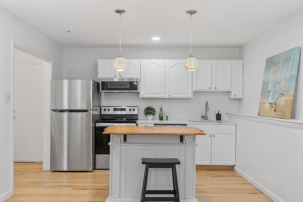 6 Leonard Road, Unit 6 Boxborough, MA 01719 - Photo 7 of 28 a kitchen with stainless steel appliances granite countertop a refrigerator a sink dishwasher a stove and white cabinets with wooden floor