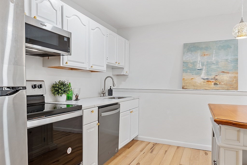 6 Leonard Road, Unit 6 Boxborough, MA 01719 - Photo 8 of 28 a kitchen with stainless steel appliances white cabinets and a sink