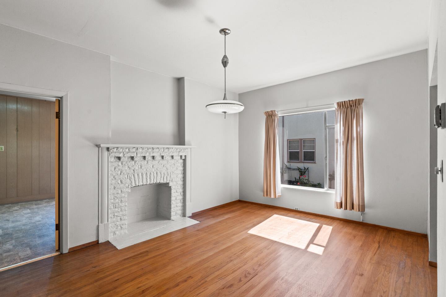 716 Prospect Row San Mateo, CA 94401 - Photo 7 of 39 an empty room with wooden floor fireplace and windows