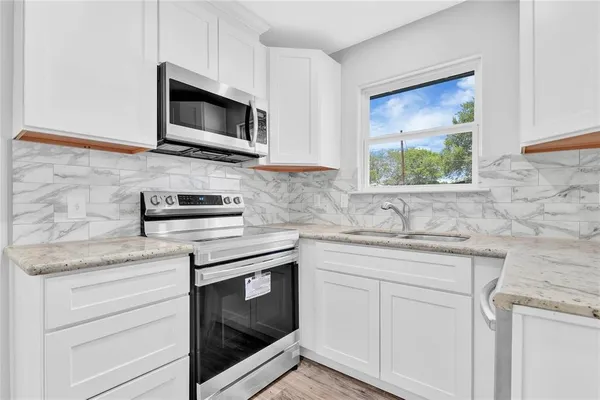 a kitchen with white cabinets stainless steel appliances and sink