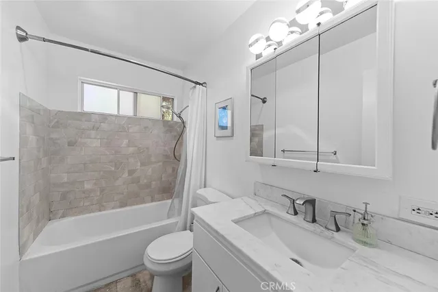 a bathroom with a sink a toilet and a large mirror