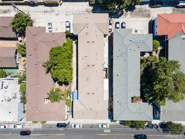 an aerial view of residential houses with outdoor space and parking