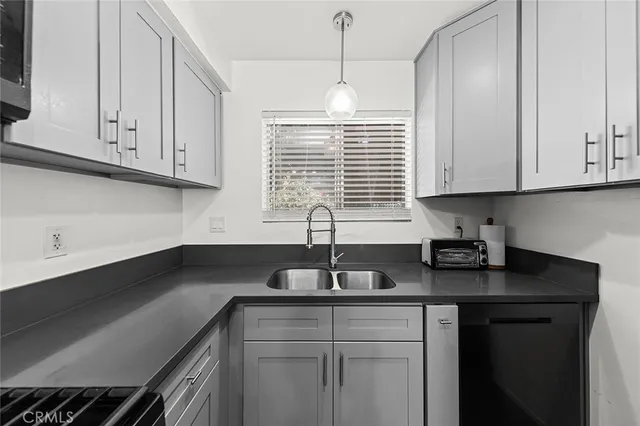 a kitchen with granite countertop white cabinets white appliances and a sink