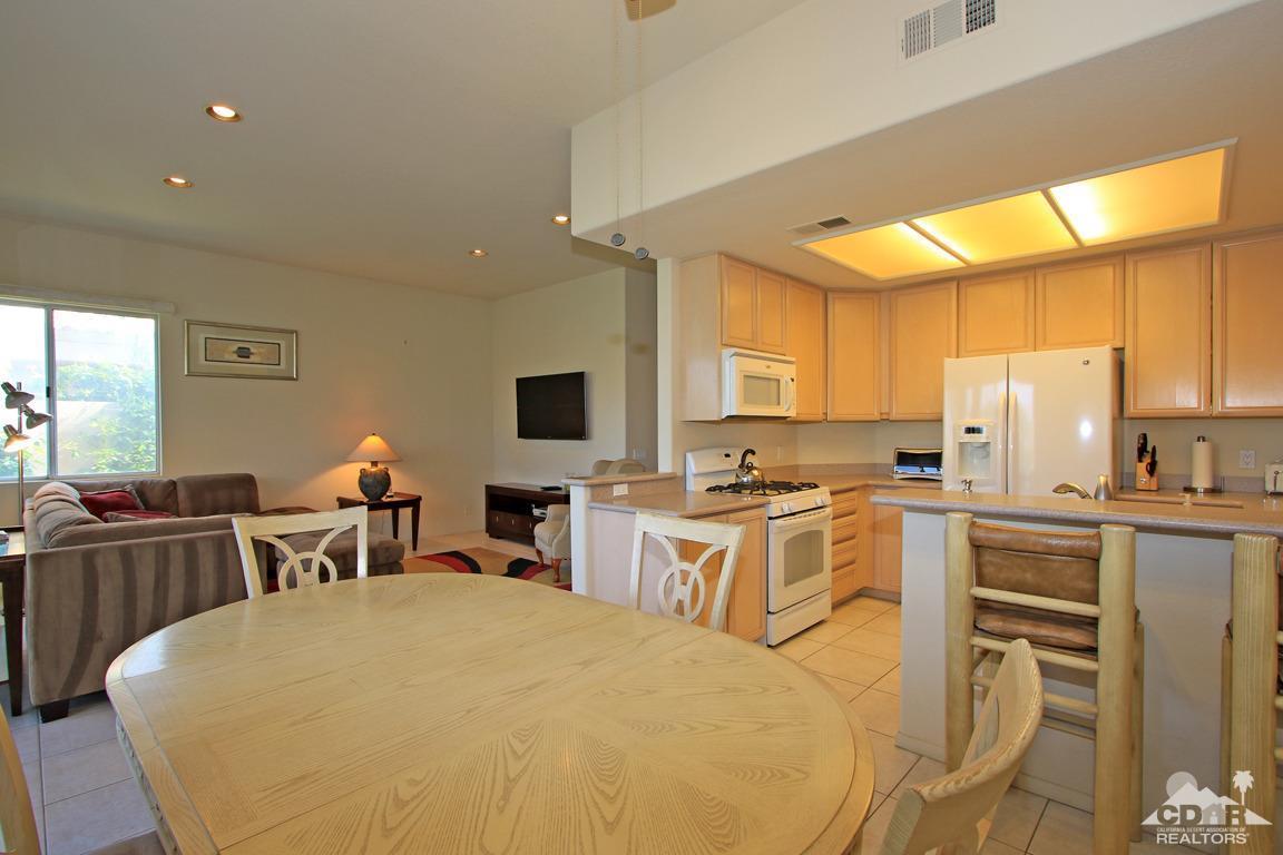 15 Augusta Drive Rancho Mirage, CA 92270 - Photo 14 of 35 a large white kitchen with a table chairs wooden cabinets and stainless steel appliances
