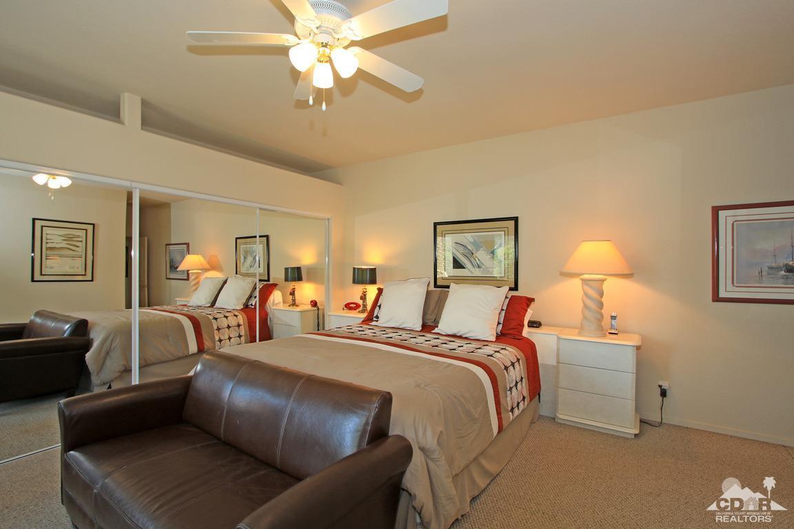 15 Augusta Drive Rancho Mirage, CA 92270 - Photo 17 of 35 a bedroom with furniture and a chandelier