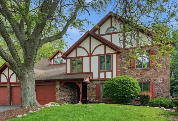 front view of house with a yard and an trees