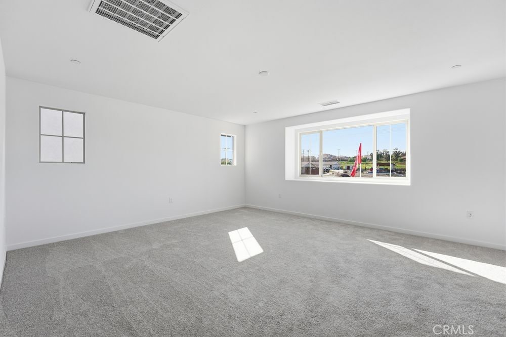 9575 Silverstein Drive Riverside, CA 92508 - Photo 8 of 22 an empty room with windows and cabinet