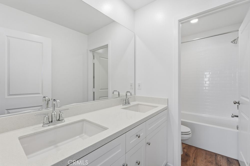 9575 Silverstein Drive Riverside, CA 92508 - Photo 10 of 22 a bathroom with a granite countertop sink a toilet and shower