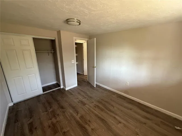 a bedroom with a bed and a dresser next to a window