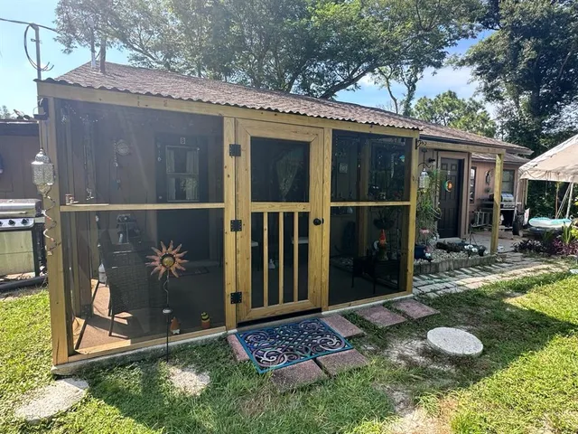 a view of backyard with potted plants and a large tree