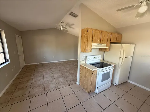 a kitchen with a sink a wooden floor and a large window