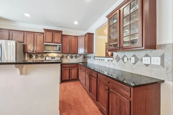 a kitchen with stainless steel appliances granite countertop a sink stove and refrigerator