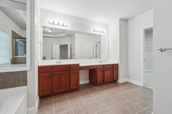 a spacious bathroom with a granite countertop sink and a mirror