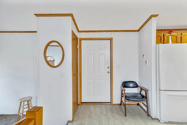 a view of a hallway with entryway wooden floor and front door