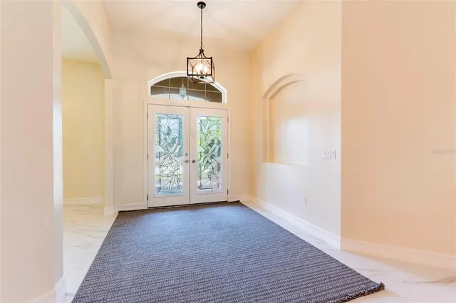 a view of hallway with wooden floor and chandelier