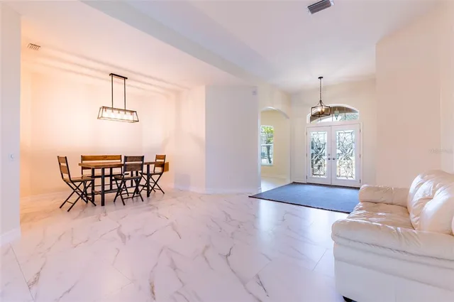 a kitchen with stainless steel appliances granite countertop a stove a sink dishwasher a refrigerator and white cabinets with wooden floor