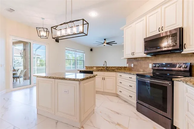 a kitchen with granite countertop a sink appliances cabinets and a counter top space