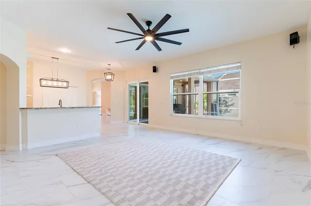 a view of empty room with wooden floor and ceiling fan