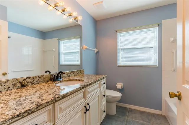 an empty room with closet and a chandelier fan