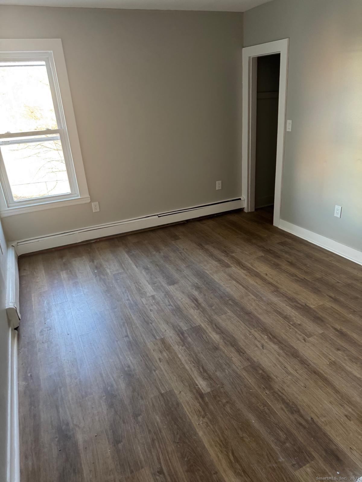 422 Lafayette Street, Unit 1R Bridgeport, CT 06604 - Photo 13 of 15 an empty room with wooden floor and windows