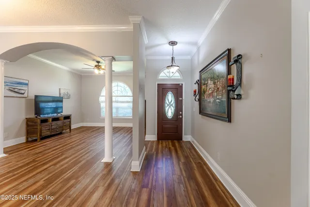 a kitchen with stainless steel appliances granite countertop a refrigerator a sink dishwasher a stove and white countertops with wooden floor