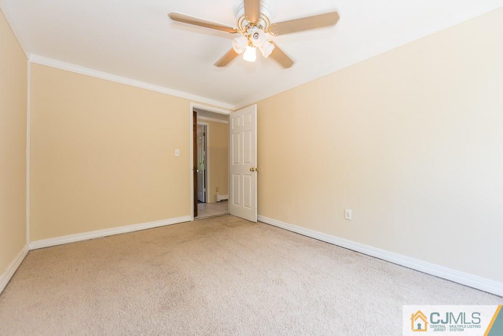 1518 Englishtown Road Old Bridge, NJ 08857 - Photo 18 of 25 an empty room with a ceiling fan and a window