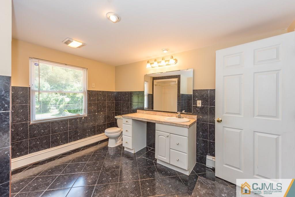 1518 Englishtown Road Old Bridge, NJ 08857 - Photo 21 of 25 a spacious bathroom with a granite countertop sink a toilet mirror and a bathtub
