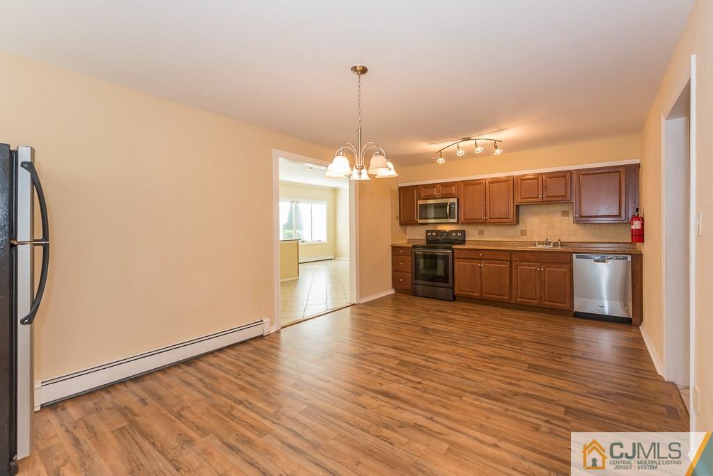 1518 Englishtown Road Old Bridge, NJ 08857 - Photo 5 of 25 a view of a kitchen with a sink a refrigerator and a stove top oven