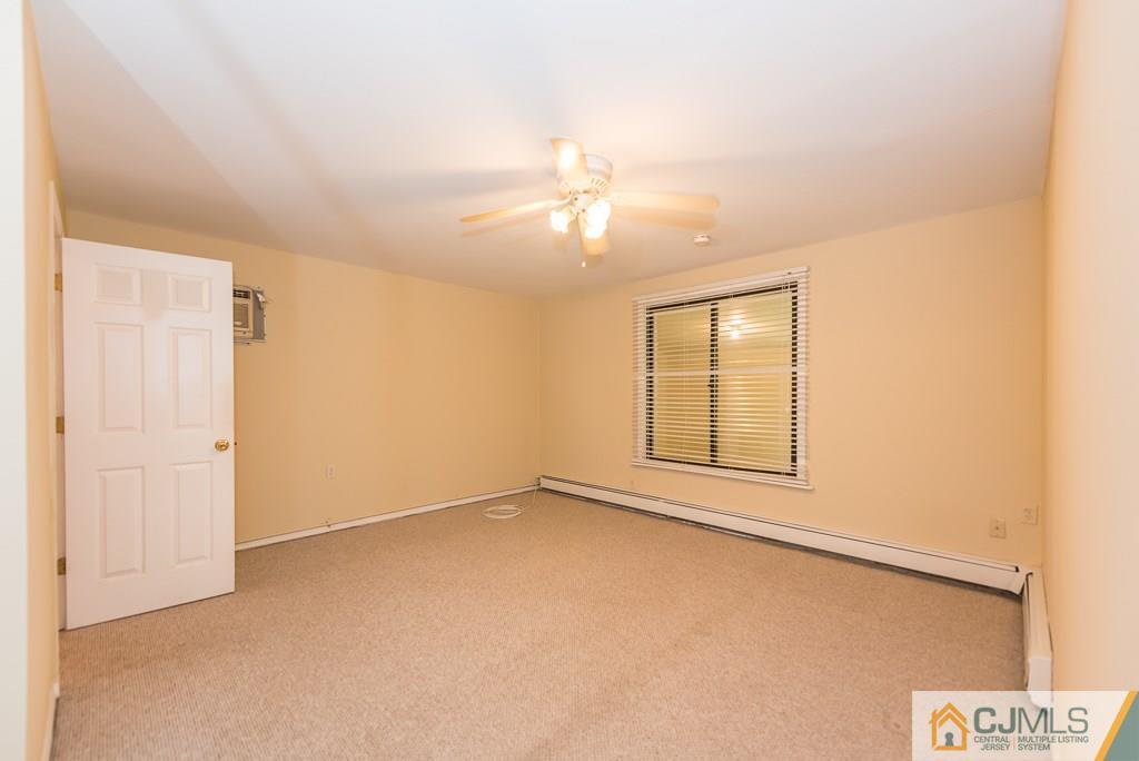 1518 Englishtown Road Old Bridge, NJ 08857 - Photo 8 of 25 an empty room with chandelier fan and windows