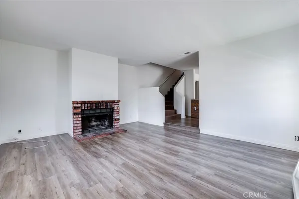 a view of empty room with wooden floor and fireplace