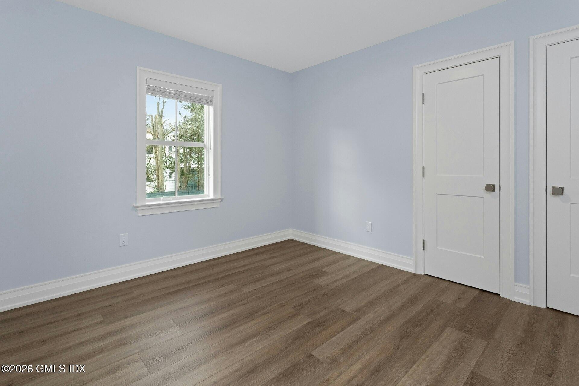 104 Pemberwick Road, Unit 1 Greenwich, CT 06831 - Photo 13 of 18 an empty room with wooden floor and a window