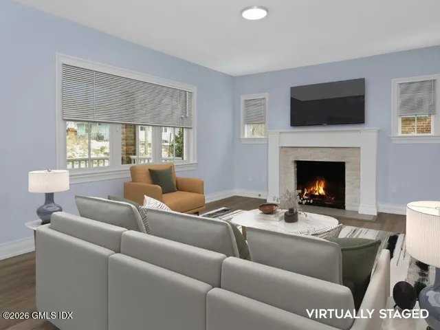 a living room with furniture a flat screen tv and a fireplace