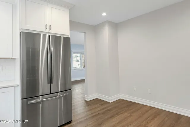a view of empty room with wooden floor and window