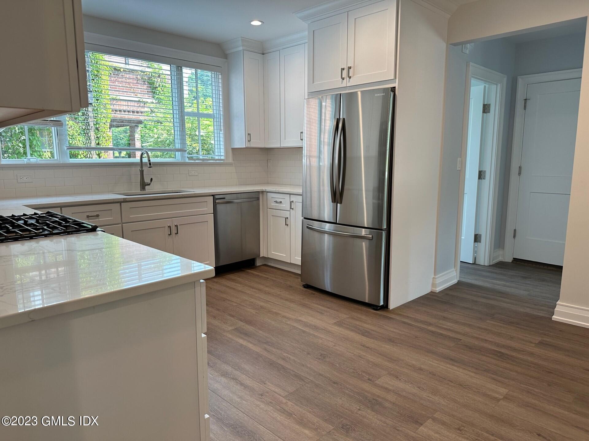104 Pemberwick Road, Unit 1 Greenwich, CT 06831 - Photo 7 of 18 a kitchen with wooden cabinets and a refrigerator