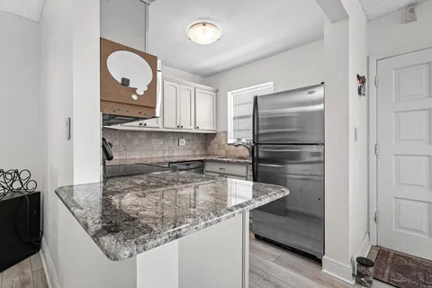 a kitchen with granite countertop a sink and a stove
