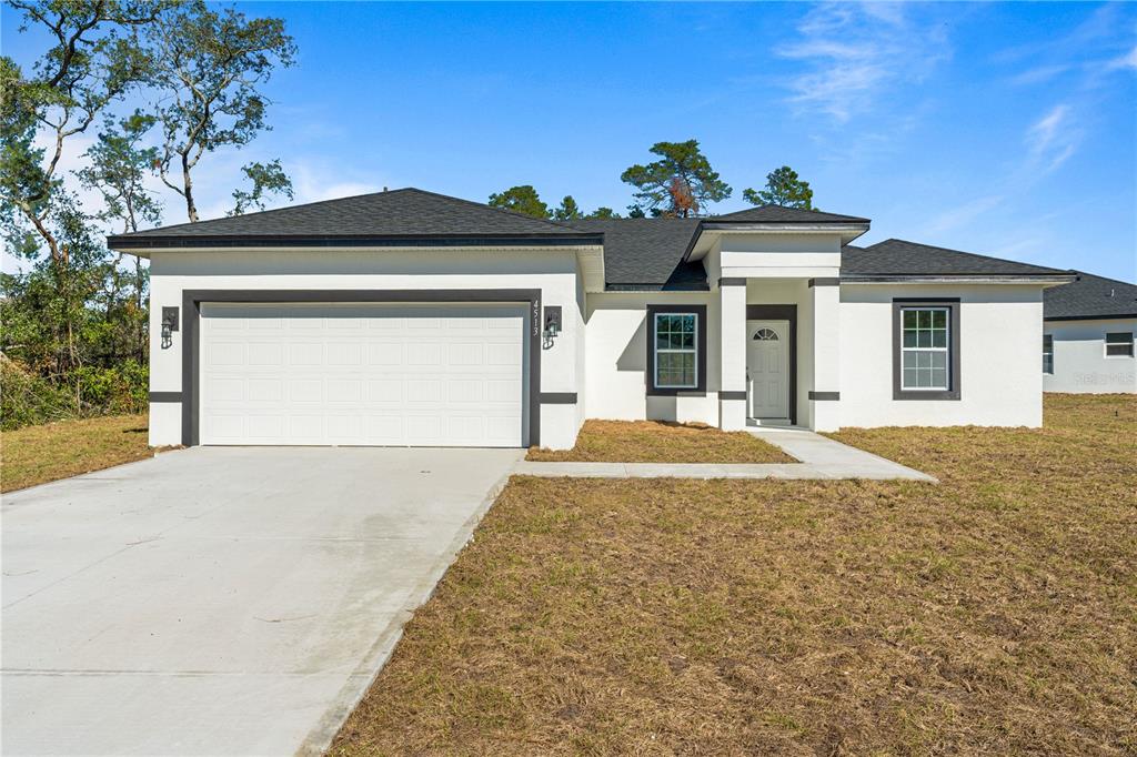 4513 Southwest 170th Street Road Ocala, FL 34473 - Photo 1 of 1 a front view of a house with a yard and garage