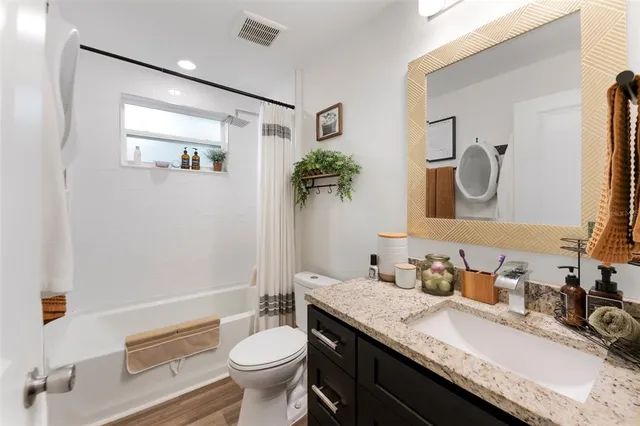 a bathroom with a granite countertop sink mirror and toilet