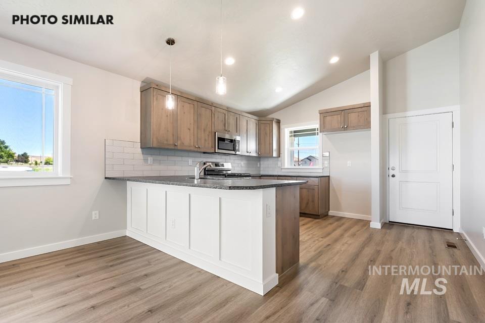 1693 Rapid Road Emmett, ID 83617 - Photo 9 of 28 Open-concept kitchen featuring wood-finish flooring, vaulted ceilings, and recessed lighting