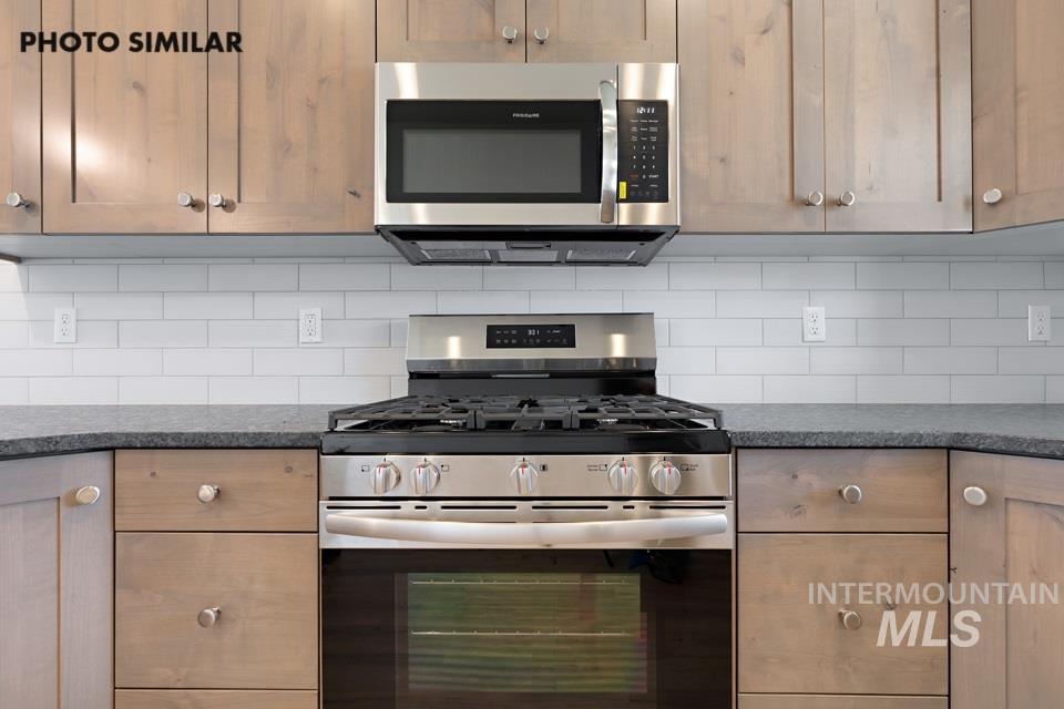 1693 Rapid Road Emmett, ID 83617 - Photo 10 of 28 Kitchen featuring a stainless steel range with a built-in oven, coordinating microwave, light wood-finish cabinetry, and dark countertops