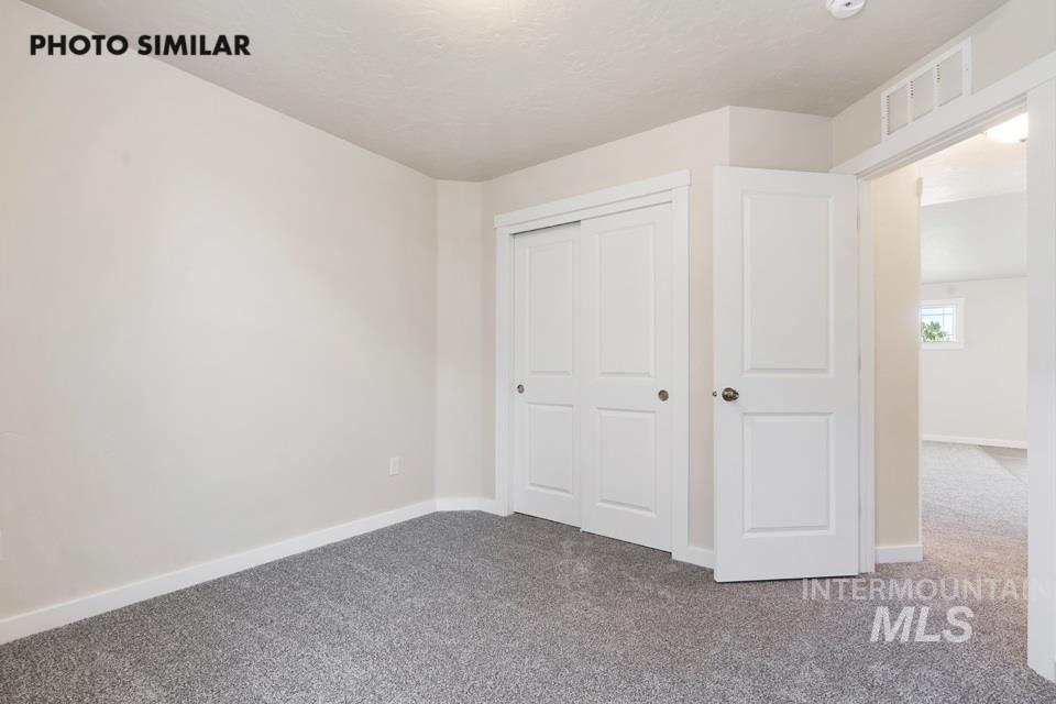 1693 Rapid Road Emmett, ID 83617 - Photo 21 of 28 Bedroom with light gray walls, gray carpeting, white baseboards, and a white sliding closet door